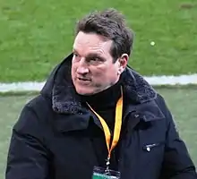 A man with dark hair wearing a winter jacket