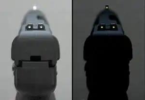Photo of the tritium-illuminated fixed sights of the Five-seven USG pistol, in normal and dim lighting.