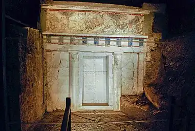 Facade of an underground structure with a painting above the door.