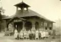 An early photo of the teacher and students of the Felta School, c. 1910.