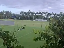 Florida Gulf Coast University soccer field, with blue scoreboard that reads "FGCU" and "Pickering Field", as well as bleachers