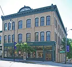 Three story brick building with wood trim over the retail ground floor