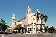 The First Baptist Church of Los Angeles, a tan church with palm trees in front