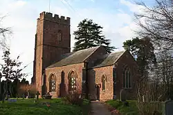 Reddish building with square tower.