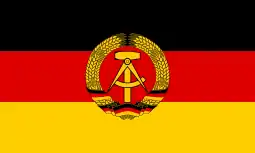 The flag of East Germany (1959–90). It differs from the West German flag by the presence of a communist symbol in the center, and it fell out of use when Germany was reunified after the fall of the Berlin Wall.