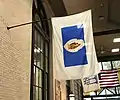 A variant of the flag seen in Metro Center, Springfield; note the absence of gold trim, banner with only gold and white, lighter blue, wider white field, and Puritan facing leftward