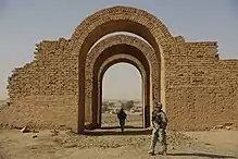 A series of three arched gates made of simple stones. They appear to be the only part that has survived from a larger building.