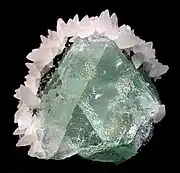 Green fluorite framed by white calcite, Naica Mine, mined in the 1980s. Size: 5.5 cm × 5.1 cm × 4.4 cm (2+1⁄4 in × 2 in × 1+3⁄4 in).