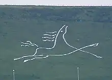 A stylised figure of a galloping white horse. Folkestone White Horse on Cheriton Hill, Folkestone