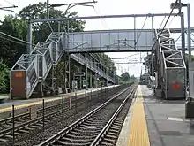 A footbridge over an electrified railway line, with staircases boarded off