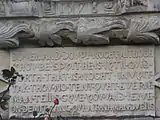 Inscription plaque below coats of arms set into one of the towers