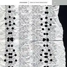 Depicts a crumpled and hole punched page.  Only the right edge of the paper is visible which is torn ragged. The page covered with numbers and letters.
