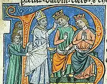 A man and a woman, both wearing a crown, and sitting on a throne with a bishop touching the man's forehead.