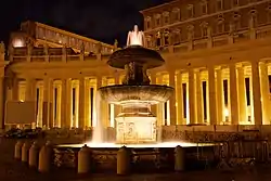 View of one fountain which rises in two tiers from a sculptured pool. The fountain is playing and the water is sparkling.