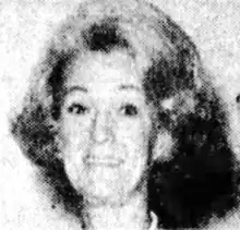 A middle-aged white woman with hair in a bouffant style