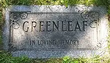 Flat red and grey granite stone inscribed with the name Greenleaf