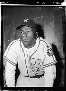 Fred Thomas in a baseball dugout wearing a Kitchener Panthers uniform.