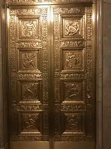 A double-leaf elevator door in the lobby, with gilded carvings