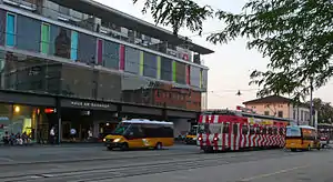 Boxy three-story structure with red tram in front