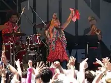 A woman in bright clothing on stage.
