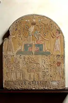 Kha adores the gods Osiris and Anubis and is seated with his wife to receive offerings from their son