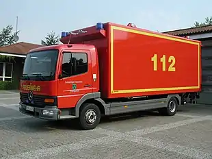 Red fire truck with 1-1-2 painted in yellow on its side