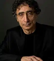 close-up of Gabor Maté wearing a black jacket, looking directly at camera