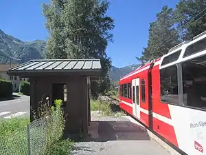 White-and-train on single-track railway line next to side platform
