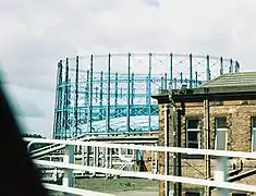 The gas holders of Provan Gas Works, on the skyline in Glasgow; pipework and the booster house can also be seen.