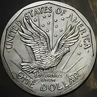 One side of a coin design, depicting an eagle flying above a mountaintop