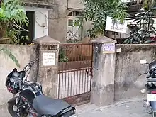 Gate to a building with signboard of the address and residents