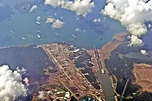 Aerial view of Gatun Locks, Panama Canal. On top, several vessels waiting at Gatun Lake to cross the locks. At the bottom is exit canal to the Atlantic Ocean (Caribbean Sea)