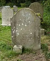 A granite headstone among other headstones
