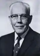 Black-and-white photograph of George S. Richardson. In the photograph, which depicts the subject's head and shoulders, Richardson is weawring a dark suit and dark tie with a white shirt, along with horn-rimmed eyeglasses. Richardson is a older Caucasian male, with white hair worn swept back from his forehead.
