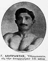 Black and white circular headshot photo of a topless man with thick black hair and a thick black moustache