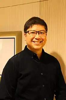 An image of Salonga in wearing eyeglasses and black long-sleeved shirt
