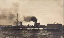 A German Torpedo boat cruising at sea with smoke billowing from a stack amidships.