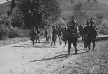 Soldiers escorting civilians with bound hands