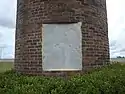 A brick pedestal with a stone plaque which reads: “This monument to the peanut, Turner County's most important agricultural product, is dedicated to the memory of Nora Lawrence Smith, December 25, 1886 - July 17, 1971.  Member, Georgia Journalism's Hall of Fame, Editor and Co-Publisher of the Wiregrass Farmer, Turner County's Award Winning Newspaper and an untiring supporter of Turner County and its agricultural economy."