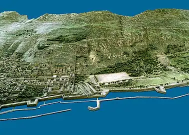 1865 model of Gibraltar from the west.  The stepped structure of the upper King Charles V wall is to the right of center at the top.  The lower portion, further to the left, runs straight up from the waterfront to the cliff.