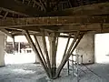 Horse shaft fixed to one of four long beams, all braced to each other with stretchers, and each fixed to the side of the top of the main axle.