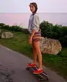 Skater riding her cruiser along the coast