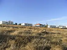 Five residential buildings overlooking scrub grass