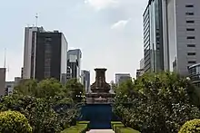 An empty pedestal surrounded by a protective fence.