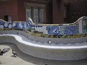 The unique shape of the serpentine bench enables the people sitting on it to converse privately, although the square is large. The bench is tiled and in order to dry up quickly after it rains, and to stop people from sitting in the wet part of the bench, small bumps were installed by Gaudí.