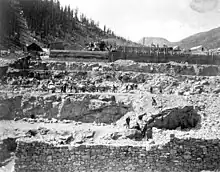 Gold Prince Mill construction, 1904:  shows miners working on blasted embankments, a horse-drawn wagon, concrete forms, and a mixing plant.