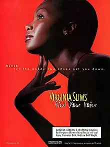 Ad showing a young, carefully made-up, dark-skinned model leaning forwards, looking upwards and delicately touching her extended throat; she is nearly exactly in profile, in silhouette on a bright red ground, with the light catching only her face, throat, fingers, and a single clear stone in her earlobe. Her hair seems very closely cropped. A subtle white overlaid text reads "NEVER let the goody two shoes get you down" and, in a much larger shadowed yellow hand-written-looking font, "Find your voice"