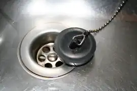A sink drain cover and a plastic sink plug
