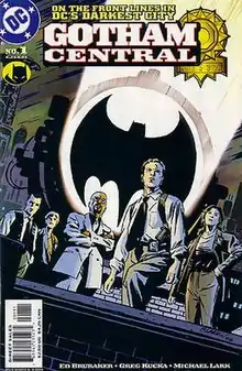 Five police officers on a rooftoop, standing in front of the 'Bat signal' searchlight.