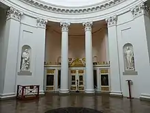 An image of the east side of the Mausoleum's interior, with the iconostasis separating the chancel behind two pillars. The Apostles Matthew and John flank it in their wall niches.